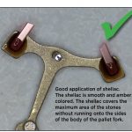 Good application of shellac. The shellac is smooth and amber colored. The shellac covers the maximum area of the stones without running onto the sides of the body of the pallet fork.